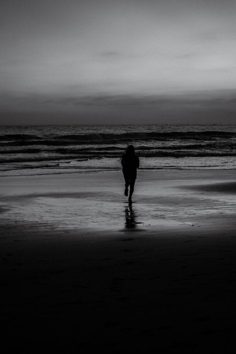 man in black jacket walking on beach during daytime