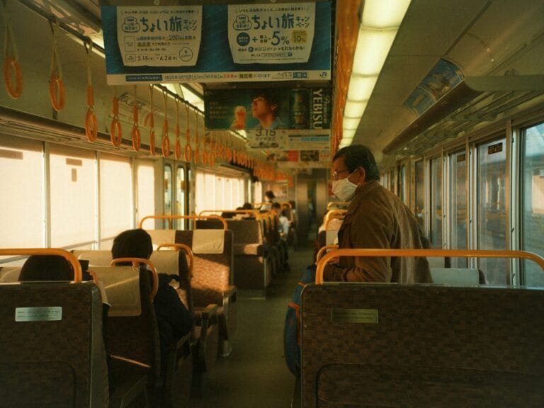 People ride a mostly empty train car.