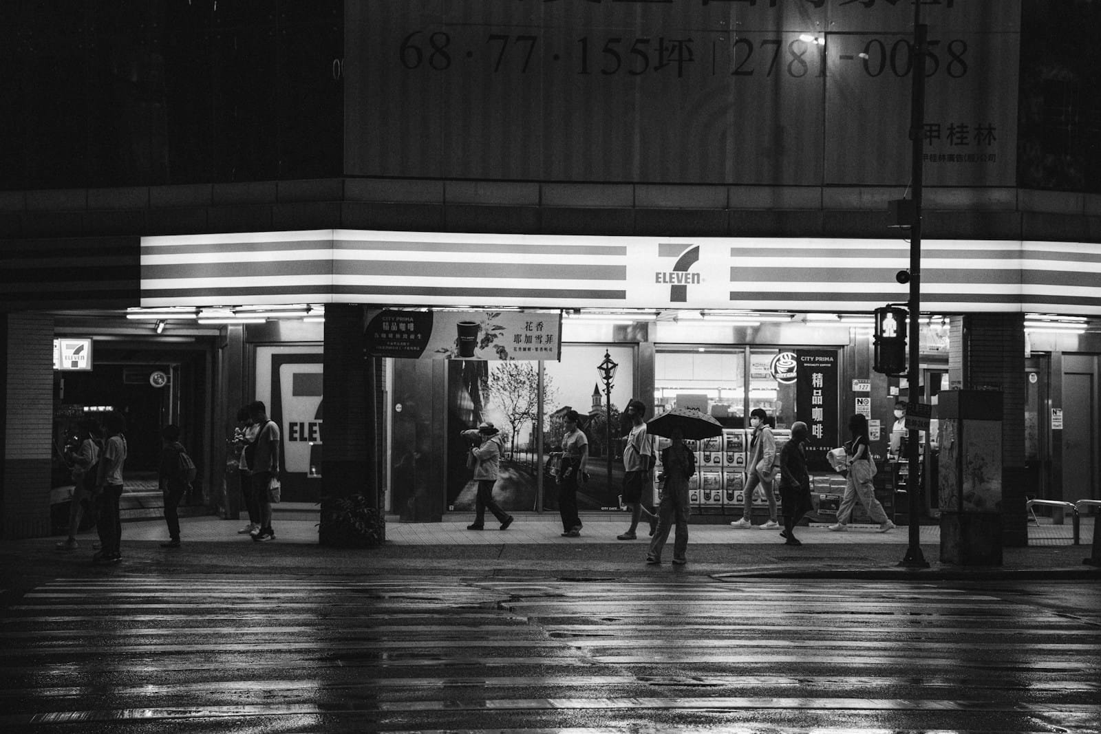 A black and white photo of people walking in the rain