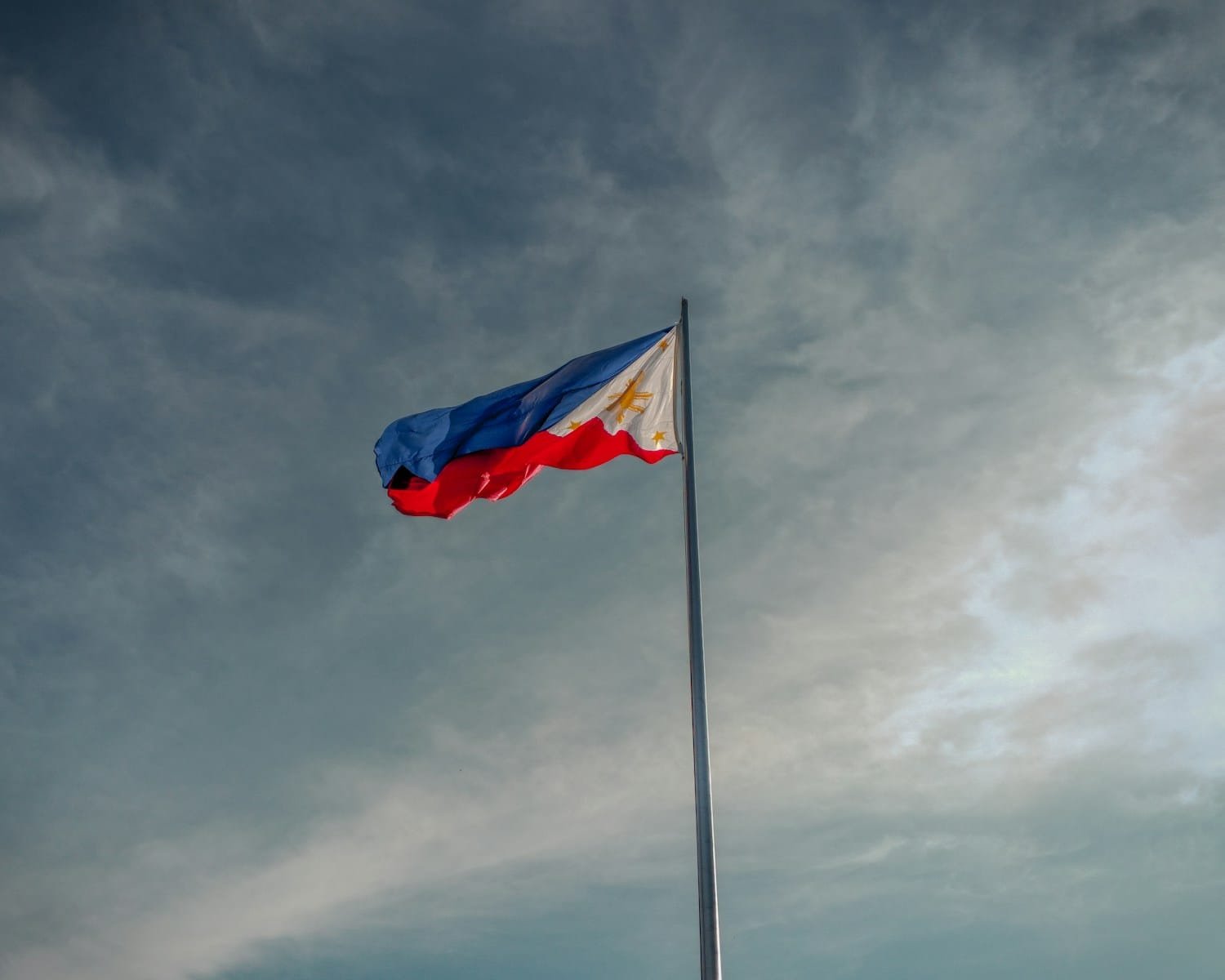 a flag flying in the wind on a cloudy day